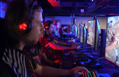 A team on stage at ELITE Gaming playing in a tournament.