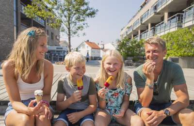 Bilde av en familie som sitter på brygga å spiser is