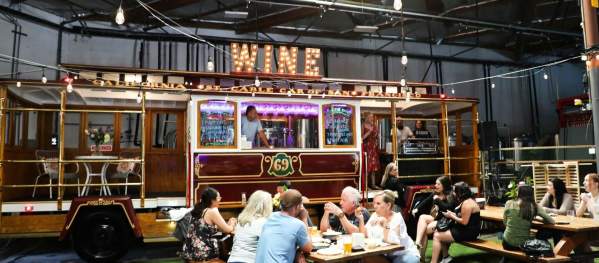 Interior view of the Off The Rails Winery tasting room,  wth picnic tables and a train car.