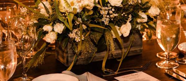 Table setting inside granite walled room with white floral centerpiece