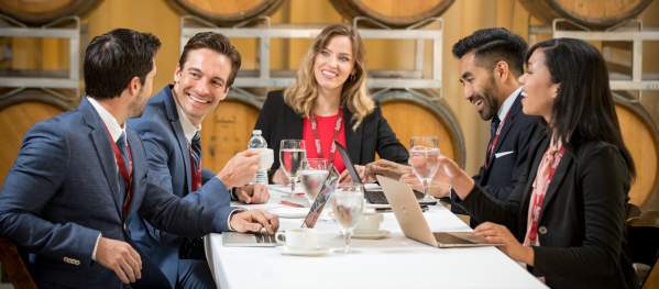 A group of professionals holds a meeting in a wine cellar
