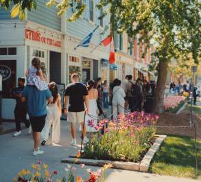 Crowd walking on sidewalk in front of heritage shops