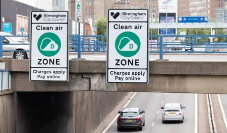 Signs next to road warning clean air zone charges apply