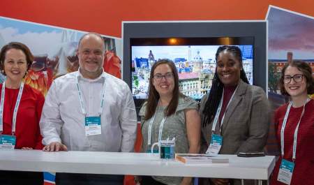 Five people in front of a trade show stand