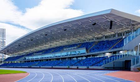 Alexander Stadium athletics stadium blue running track in front of matching two-tier stand seating.