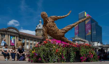 A sculpture in Victoria Square during the Commonwealth Games, above a bed of bright flowers