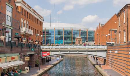 A view down the canal, on a sunny day, of the Utilita Arena Birmingham