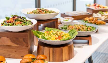 A buffet spread of an assortment of food, next to a window overlooking Birmingham