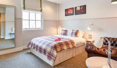 A double bed with leather sofa in bed and breakfast accommodation