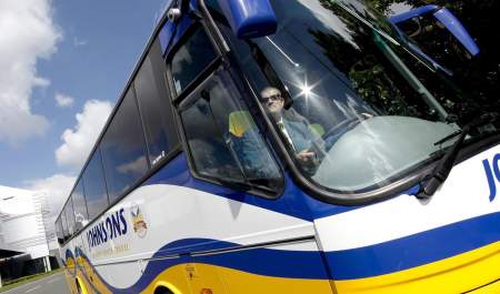 Blue white and yellow Johnsons coach driving through Birmingham