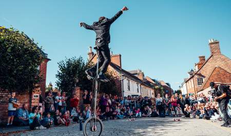 Man on unicycle in front of large crowd