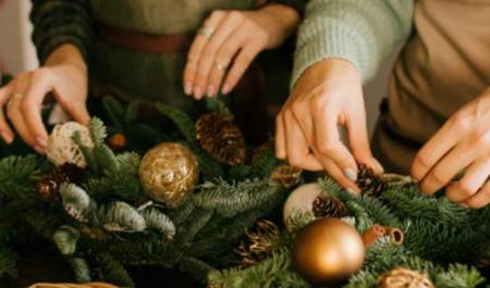 Two people making Christmas wreaths