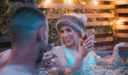 A couple enjoy a glass of wine in a hot tub at Cotswold Farm Park