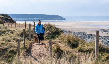 dog walkers at Westward Ho beach, spring, autumn