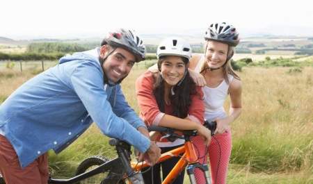 three people with bikes cycling through the countryside