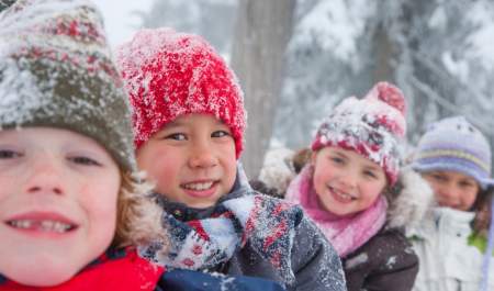 photo of four children in winter looking happy and having fun