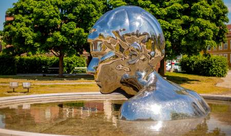 Skulpturen Genesis i krom og vannspeilet rundt, i Sarpsborg. Foto.