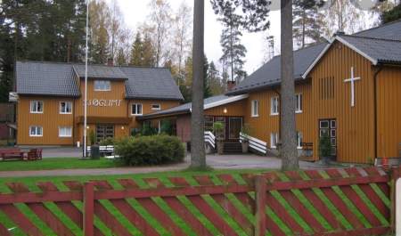 To store okergule inngjerdede bygninger med ett kors på den ene veggen