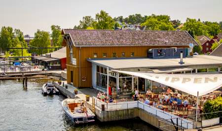 Restaurant i kanalen i Fredrikstad med uteservering og båter som ligger ved siden av restaurant Slippen