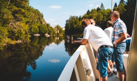 Fire personer står ved relingen på skipet, og ser utover Haldenkanalen