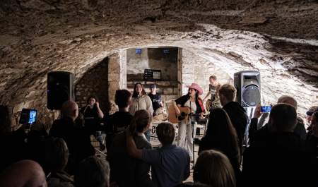Music group playing an intimate performance at Music In The City in front of small crowd inside city vault