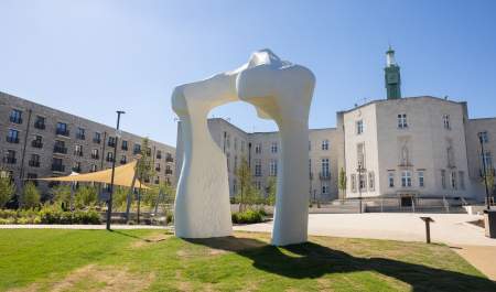 Henry Moore’s The Arch sculpture, life sized replica, located on the grounds of the gardens at the rear of Waltham Forest Town Hall, Walthamstow, E17. Town Hall buildings, clock tower and other sculptures to the walls can be seen.
