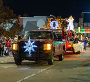 A truck with lights saying "Joy" driving through Downtown Salina, Kansas in the Holiday Festival Parade, 2025