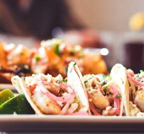 plates of fish tacos and potato chip nachos