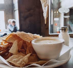beer cheese dip dripping from chip