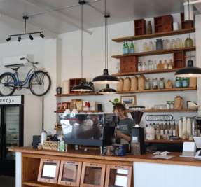 woman stands behind counter at local cafe