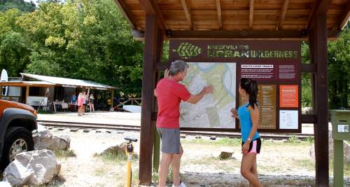 Couple Looking at Urban Wilderness Trail Map Board