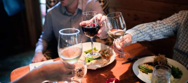 A group of people at dinner raising their wine glasses for a toast.