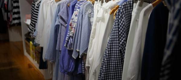Blue and white clothing hanging up in a store.