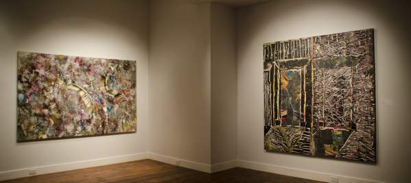 Two large abstract paintings hanging up in an art exhibit.