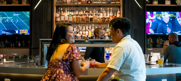 couple sitting at a bar enjoying some drinks