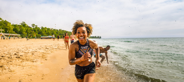girl running on the beach with her friends following behind