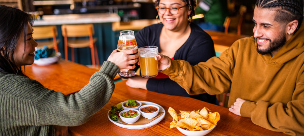 smiling friends cheersing at table