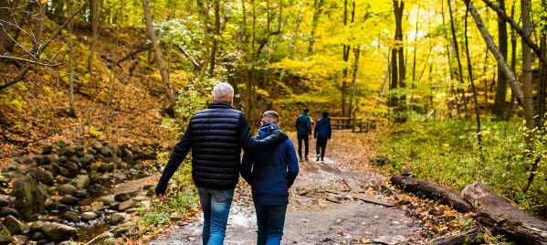 family walking on trail with fall colors surrounding