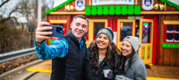 Friends taking selfie in front of the Winter Garden Tent at the Wauwatosa Holiday Market