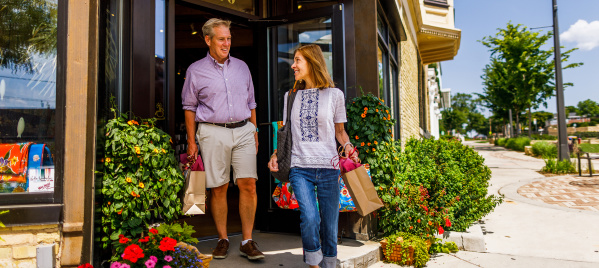 couple exiting shop with bags