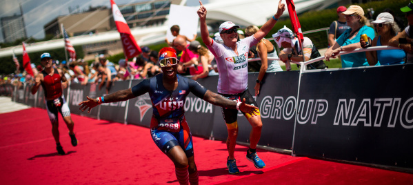 triathlete crossing the finish line in front of the Milwaukee Art Museum at the 2022 USA Triathalon
