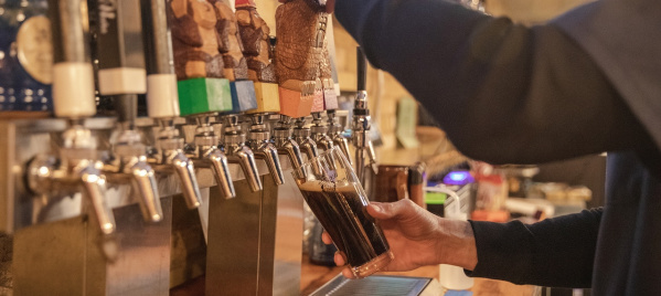 Bartender pouring a pint of beer at Wizard Works Brewing