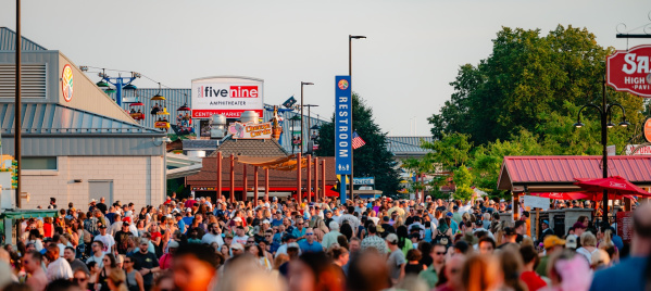 A large crowd fills the main walkway near the Five Nine Amphitheater, Central Mall and food stands during a busy afternoon at the Wisconsin State Fair.