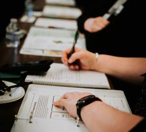 A person taking notes and writing in a binder.