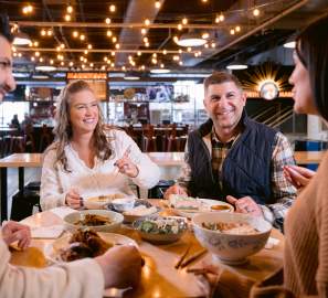 Two couples enjoying food at a community table in North Market Bridge Park