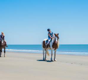 A group of visitors explore Georgia's Golden Isles beaches on horseback.