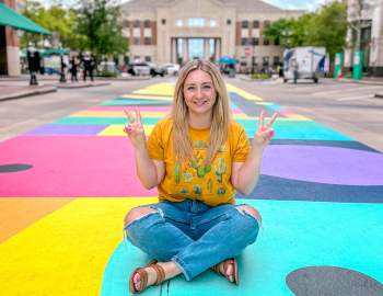 Jade sitting on pavemtn mural and smiling
