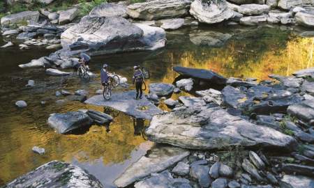 Men crossing the Big South Fork National River with their bikes