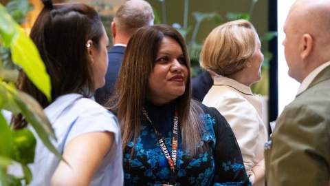 A member of the West Midlands Growth Company listens to a man dressed in a green jacket.