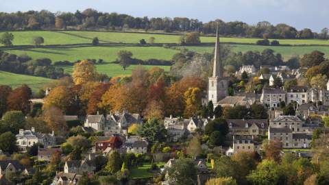 The town of Painswick with towering steeple, surrounded by autumnal countryside